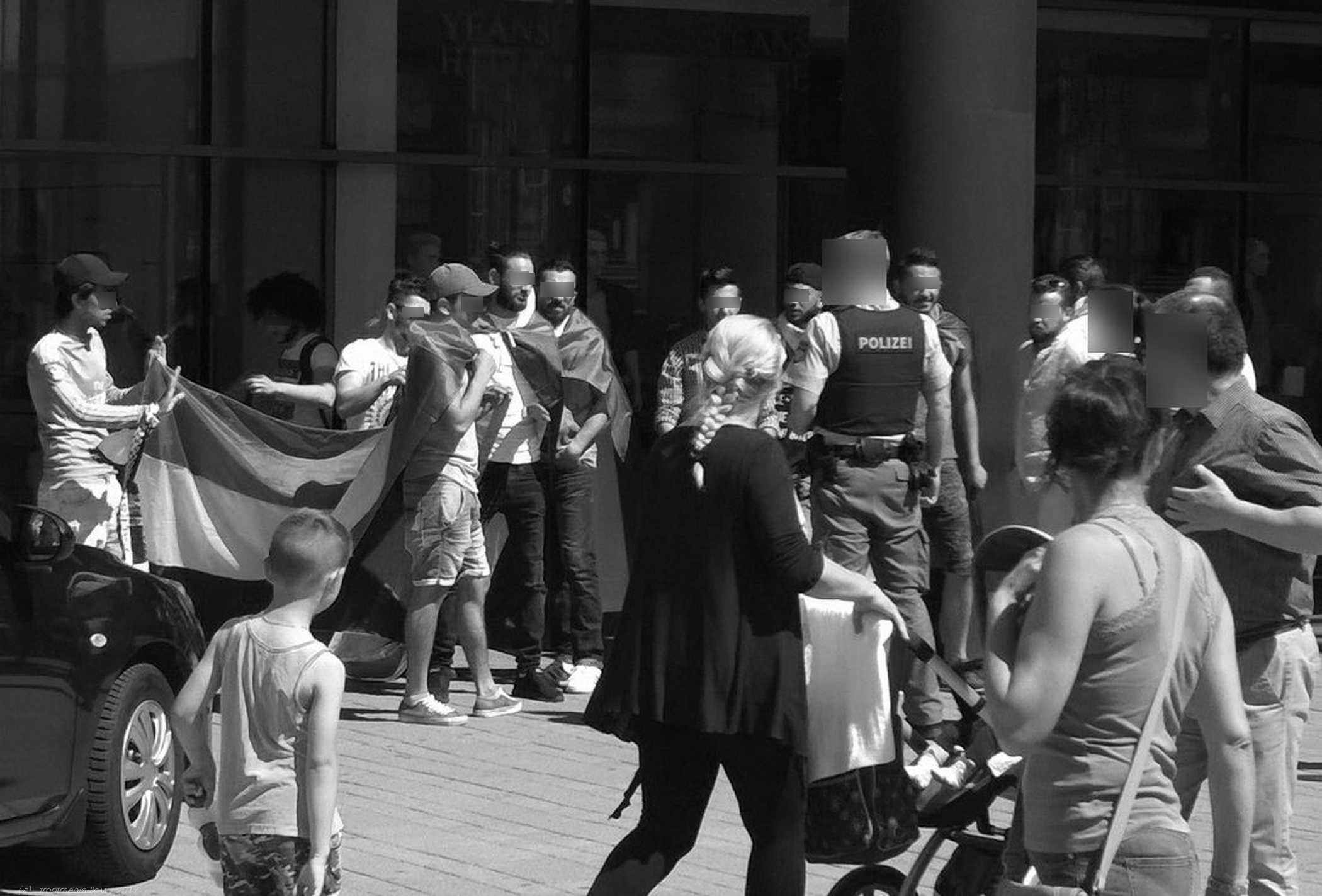 Mutter mit Kinderwagen vor der krawallbereiten Meute Mutter mit Kinderwagen vor der krawallbereiten Meute